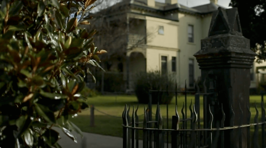 Fence and tree with blurred house in background