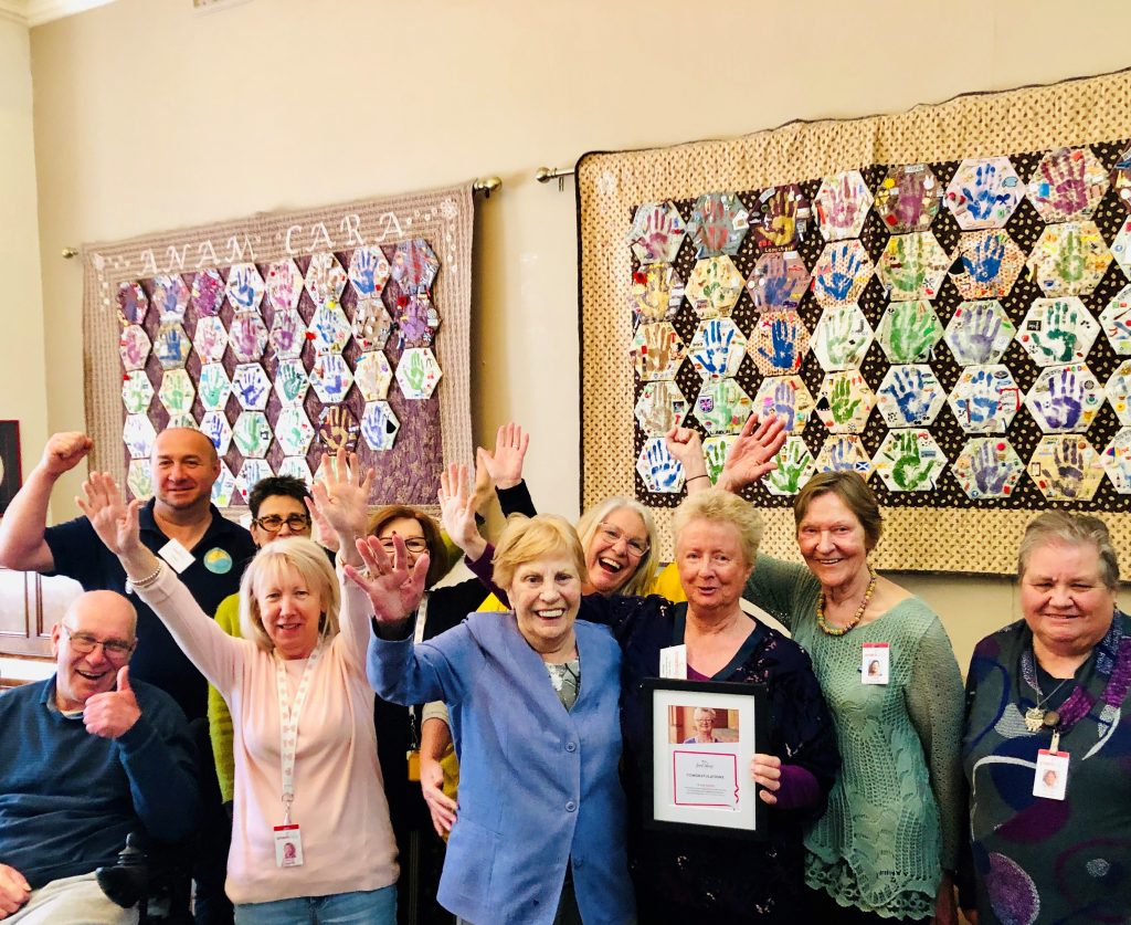 A group of people in front of patchwork displays on the wall